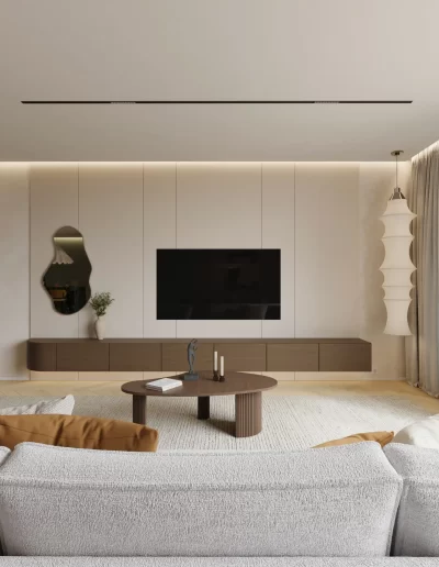 Sala de estar no projeto The Duneview House, com sofá orgânico em tecido claro, candeeiro escultórico suspenso e móvel TV flutuante.